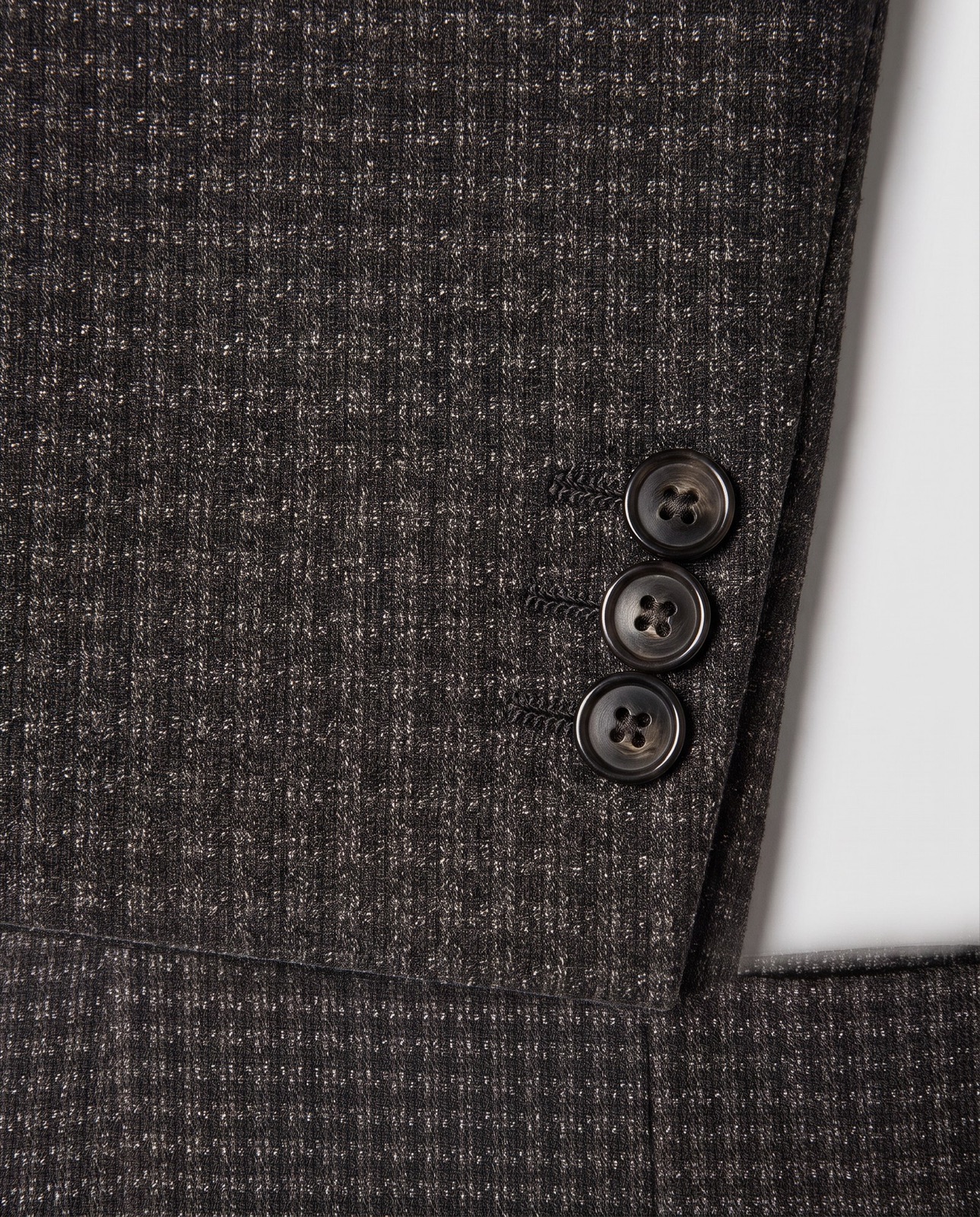 Macro detail of blazer cuff buttons and fabric weave