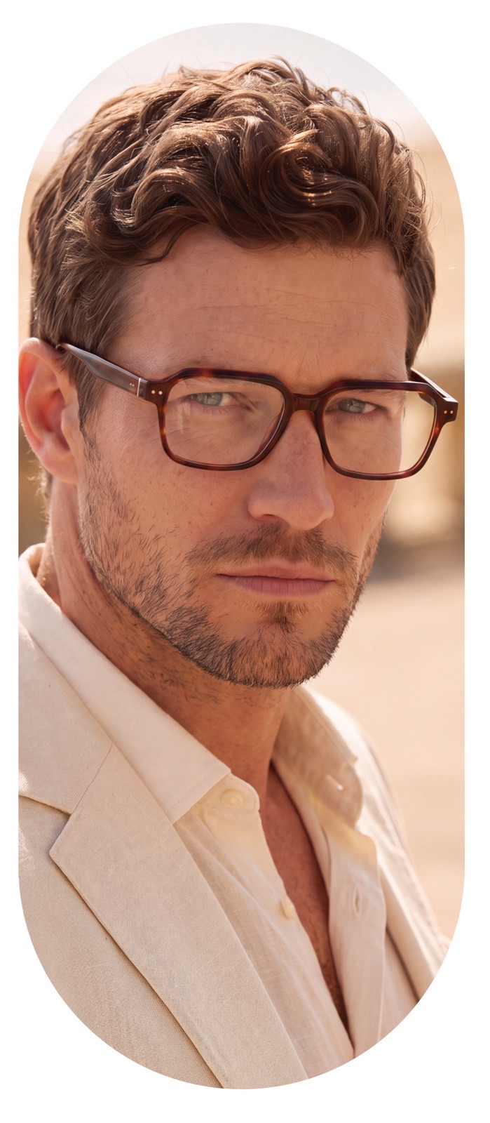 Man wearing tortoiseshell square glasses, trade show wall portrait