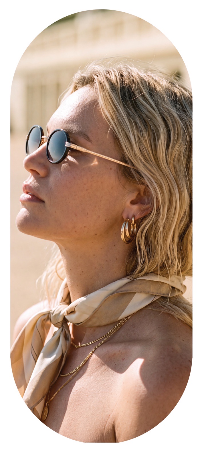 Woman wearing round sunglasses looking up, trade show wall portrait