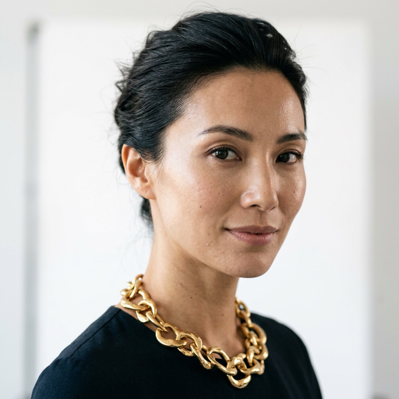 Close-up portrait of a woman wearing a chunky gold chain-link necklace